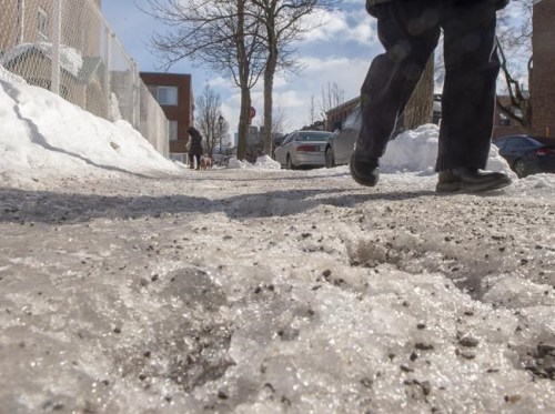 A pedestrian makes his way along an icy sidewalk Tuesday, February 26, 2019 in Montreal. Cycles of above normal to freezing temperatures have caused ice build-up on many of the city's sidewalks.THE CANADIAN PRESS/Ryan Remiorz