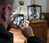 A visitor to the St. Boniface Museum on Louis Riel Day snaps a photo of the Bell of Batoche on display inside the museum. (Melissa Tait / Winnipeg Free Press files)