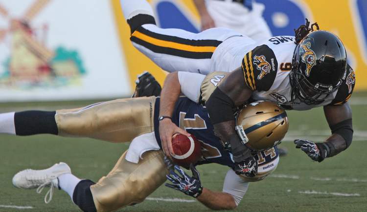 Joe Bryksa / Winnipeg Free Press
Winnipeg Blue Bombers quarterback Joey Elliott is sacked by Hamilton Tiger-Cats' Renauld Williams during second-quarter CFL action at Canad Inns Stadium Thursday.