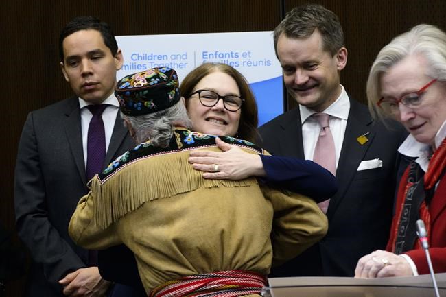 Metis National Council Clement Chartier hugs Jane Philpott, President of the Treasury Board and Minister of Digital Government, during a press conference regarding the introduction of Bill C-92, An Act respecting First Nations, Inuit and Métis children, youth and families in Ottawa on Thursday, Feb. 28, 2019. Indigenous Services Minister, Seamus O'Regan, back right, and Natan Obed, president of Inuit Tapiriit Kanatami, look on. THE CANADIAN PRESS/Sean Kilpatrick