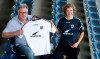 Thoralf Hintze, left, member of the board of the German fourth division soccer club Babelsberg 03, and Liza Pflaum, spokeswomen of the 'Seebruecke' (Pier) sea rescue organistion pose for the photographers after a press conference in Potsdam near Berlin, Germany, Thursday, Aug. 1, 2019. Babelsberg 03 provides its current season team jersey to the international 'Seebruecke' movement. (AP Photo/Michael Sohn)