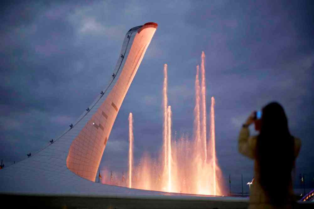 David Goldman / The Associated Press
A spectator takes a photo during the testing of a water light show at the Olympic cauldron in the Olympic Park at the 2014 Winter Olympics, Saturday, in Sochi, Russia.