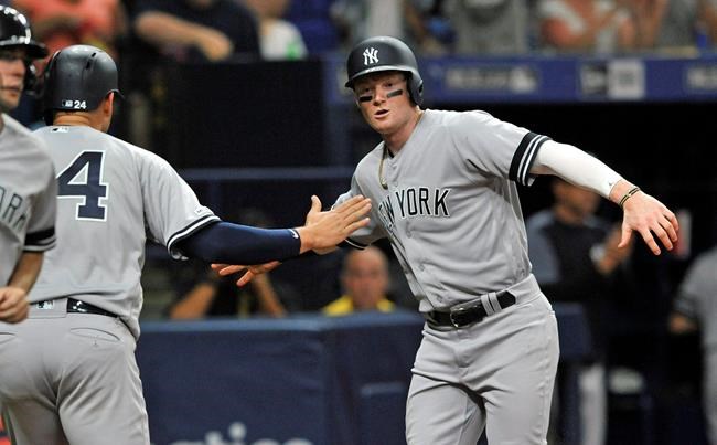 New York Yankees' Gary Sanchez (24) and Clint Frazier celebrate after scoring on Gio Urshela's two-run single off Tampa Bay Rays reliever Emilo Pagan during the sixth inning of a baseball game Friday, May 10, 2019, in St. Petersburg, Fla. (AP Photo/Steve Nesius)wb