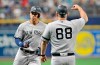 New York Yankees third base coach Phil Nevin (88) congratulates Aaron Judge, left, after Judge hit a solo home run off Tampa Bay Rays starter Brendan McKay during the first inning of a baseball game Friday, July 5, 2019, in St. Petersburg, Fla. (AP Photo/Steve Nesius)