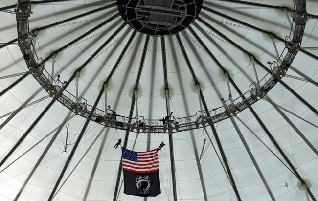 Members of the United States Special Operations Comman rappel team bring the American flag and the POW-MIA flag from the catwalk before a baseball game between the Tampa Bay Rays and the Toronto Blue Jays, Monday, May 27, 2019, in St. Petersburg, Fla. (AP Photo/Chris O'Meara)