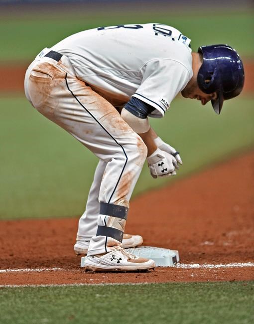 Tampa Bay Rays' Brandon Lowe stands on first base after limping to the bag on a ground-ball single to left off Baltimore Orioles starter Asher Wojciechowski during the sixth inning of a baseball game Tuesday, July 2, 2019, in St. Petersburg, Fla. Lowe hit a foul ball off his right leg during the at-bat and left the game after his base hit. (AP Photo/Steve Nesius)