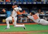 Baltimore Orioles pitcher Mychal Givens (60) dives to tag out Tampa Bay Rays' Kevin Kiermaier who was trying to score on a ground ball hit by Yandy Diaz and fielded by Givens during the eighth inning of a baseball game Wednesday, July 3, 2019, in St. Petersburg, Fla. (AP Photo/Steve Nesius)