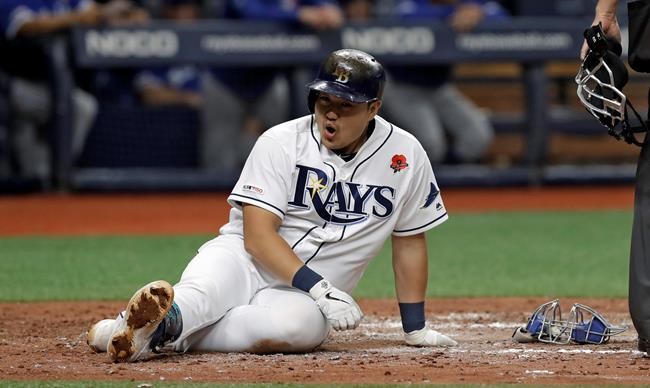 Tampa Bay Rays' Ji-Man Choi tries to catch his breath after he hit an RBI single off Toronto Blue Jays pitcher Jacob Waguespack and then scored on a throwing error by catcher Luke Maile during the fourth inning of a baseball game Monday, May 27, 2019, in St. Petersburg, Fla. (AP Photo/Chris O'Meara)