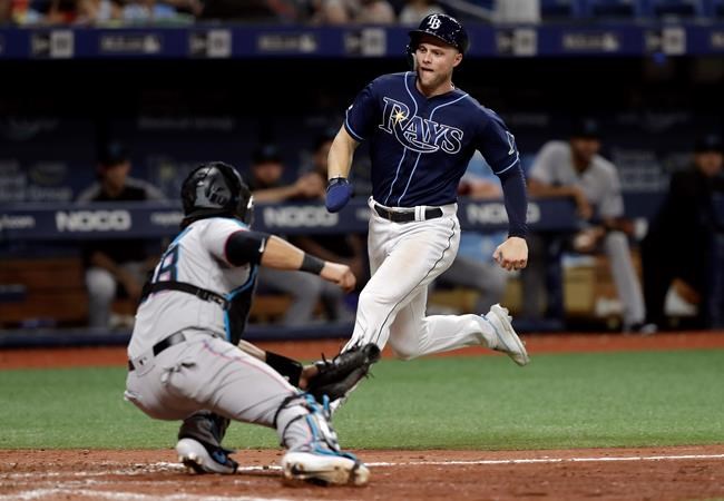 Tampa Bay Rays' Austin Meadows, right, gets tagged out by Miami Marlins catcher Jorge Alfaro while trying to score on a single by Avisail Garcia during the eighth inning of a baseball game Saturday, Aug. 3, 2019, in St. Petersburg, Fla. (AP Photo/Chris O'Meara)