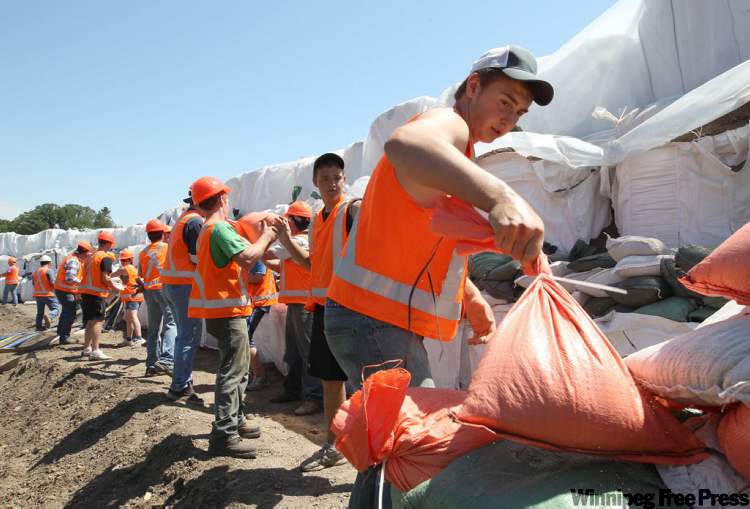 JOE BRYKSA / WINNIPEG FREE PRESS
Volunteers work to protect the water treatment plant in Souris.