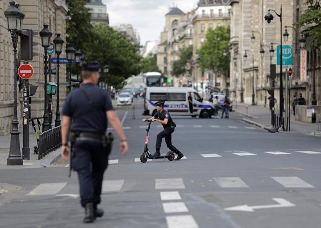 Police officers remove electric scooters from the area around Notre Dame cathedral in Paris, Monday, Aug. 12, 2019. Authorities started clearing the area around Notre Dame ahead of decontamination and cleanup work which will resume on Aug. 19 after new equipment and stricter safety procedures ensure workers are not exposed to unsafe levels of lead. (AP Photo/Lewis Joly)