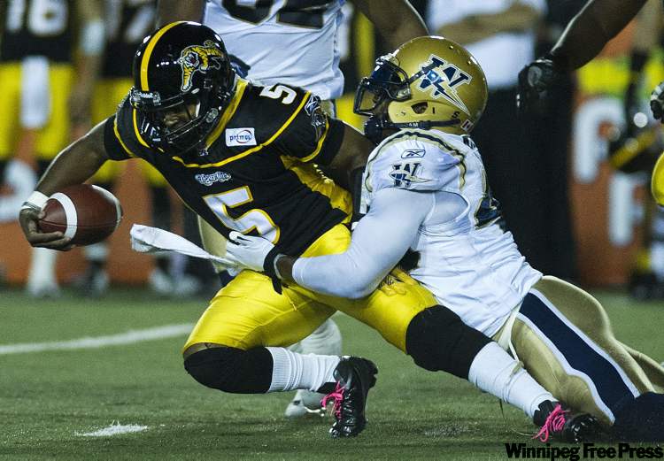 Nathan Denette / The Canadian Press
Hamilton Tiger-Cats quarterback Kevin Glenn, left, gets tackled by Winnipeg Blue Bombers linebacker Odell Willis during first-half CFL football action in Hamilton Friday.