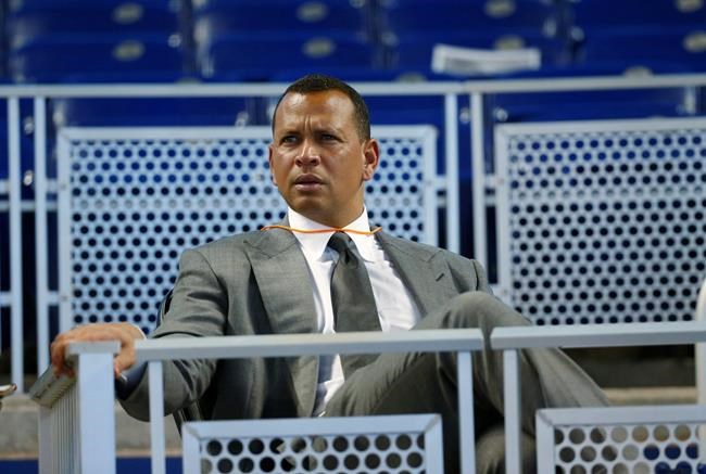 FILE - In this June 23, 2017, file photo, former baseball player Alex Rodriguez sits in the stands before the start of a baseball game in Miami. Rodriguez said he is happy with the improvements he has made in his second year in the booth for ESPN’s “Sunday Night Baseball”, but he is looking to get better during the second half of the season. (AP Photo/Wilfredo Lee, File)