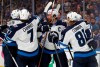 Winnipeg Jets' Dustin Byfuglien (33), Ben Chiarot (7), Blake Wheeler (26) and Kyle Connor (81) celebrate with Mark Scheifele (55) after Scheifele scored a goal against the St. Louis Blues during the third period in Game 4 of an NHL first-round hockey playoff series Tuesday, April 16, 2019, in St. Louis. (AP Photo/Jeff Roberson)