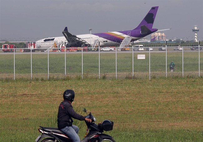FILE - In this Monday, Sept. 9, 2013 file photo, a motorcyclist looks at a damaged Thai Airways Airbus A330-300 after it skidded off the runway while landing at Sunvarnabhumi International Airport in Bangkok, Thailand. The airline has ordered an inspection of its entire Airbus A330 fleet after this week's accident involving a model that Europe's air safety authority had warned years ago has a defective part in its landing gear. Airline officials said Friday, Sept. 13, they have not found any problems in Thai's 26 other A330s but were investigating why the recommended maintenance failed to prevent a mishap outlined in a June 2011 directive from the European Aviation Safety Agency. (AP Photo/Apichart Weerawong, File)