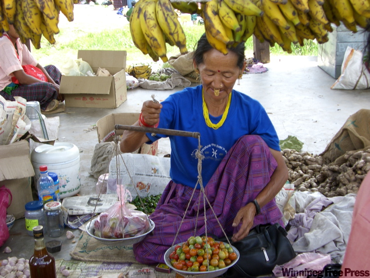 Canwest News Service
A woman at the market weighs chilies, which along with cheese, are a major part of the Bhutanese diet.