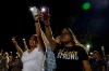 Karina Cardoso and Linda Nevarez hold their cellphone flashlights up during a vigil Sunday, Aug. 4, 2019, at Ponder Park in honor to the victims of a mass shooting occurred in Walmart on Saturday, Aug. 3, 2019, in El Paso, Texas. (Lola Gomez/Austin American-Statesman via AP)