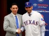 In this Nov. 5, 2018, photo, Texas Rangers' new manager Chris Woodward, right, shakes hands with General Manager Jon Daniels during a press conference in Arlington, Texas. The Texas Rangers are not only young with all those 20-something position players. They go into spring training with a first-time manager and without the retired Adrian Beltre at third base. (Rose Baca/The Dallas Morning News via AP)