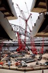 In this Monday, May 6, 2019 photo, the partially erect east roof truss is being installed with a Manitowoc 31000 crane, center, their largest capacity crawler ever designed and built, at the Texas Rangers' Globe Life Field in Arlington, Texas. The truss will support the new Daktronics right field video display measuring 58 by 150 feet. (Tom Fox/The Dallas Morning News via AP)