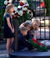 Tiffany Utterson, right, and her children, from left to right, Ella, 11, Ian, 10 and Owen, 8, place a wreath outside the gated community entrance to the home of George H.W. Bush Sunday, Dec. 2, 2018, in Houston. Bush is returning to Washington as a revered political statesman, hailed by leaders across the political spectrum and around the world as a man not only of greatness but also of uncommon decency and kindness. Bush, died late Friday at his Houston home at age 94, is to be honored with a state funeral at National Cathedral in the nation's capital on Wednesday, followed by burial Thursday on the grounds of his presidential library at Texas A&M.(AP Photo/David J. Phillip)