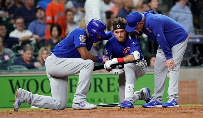 Chicago Cubs' Albert Almora Jr., center, takes a knee as Jason Heyward, left, and manager Joe Maddon, right, talk to him after hitting a foul ball into the stands during the fourth inning of a baseball game against the Houston Astros Wednesday, May 29, 2019, in Houston. (AP Photo/David J. Phillip)