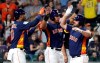 Houston Astros' Tyler White, right, celebrates with Michael Brantley, center, and Yuli Gurriel, left, after they scored on White's home run against the Pittsburgh Pirates during the third inning of an exhibition baseball game Monday, March 25, 2019, in Houston. (AP Photo/David J. Phillip)