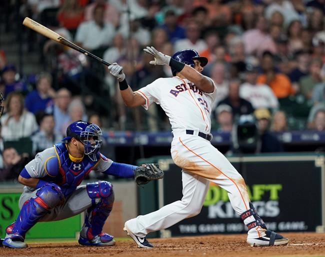 Houston Astros' Michael Brantley (23) hits a two-run double as Chicago Cubs catcher Willson Contreras reaches for the pitch during the fourth inning of a baseball game Tuesday, May 28, 2019, in Houston. (AP Photo/David J. Phillip)