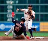 Houston Astros second baseman Jose Altuve (27) throws to first as he tries to turn a double play as Cleveland Indians' Jake Bauers (10) slides into second base during the third inning of a baseball game Sunday, April 28, 2019, in Houston. Bauers was out at second and Francisco Lindor was safe at first. (AP Photo/David J. Phillip)