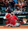 Houston Astros' Jake Marisnick, right, collides Los Angeles Angels catcher Jonathan Lucroy (20) while trying to score during the eighth inning of a baseball game Sunday, July 7, 2019, in Houston. Marisnick was called out under the home plate collision rule. (AP Photo/David J. Phillip)