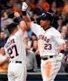 Houston Astros' Michael Brantley (23) celebrates his two-run home run off Oakland Athletics starting pitcher Aaron Brooks with Jose Altuve during the fifth inning of a baseball game, Saturday, April 6, 2019, in Houston. (AP Photo/Eric Christian Smith)