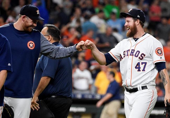 Houston Astros relief pitcher Chris Devenski, right, celebrates with Joe Biagini, who had pitched the eighth inning, the team's win and four-pitcher combined no-hitter in a 9-0 win over the Seattle Mariners in a baseball game, Saturday, Aug. 3, 2019, in Houston. (AP Photo/Eric Christian Smith)