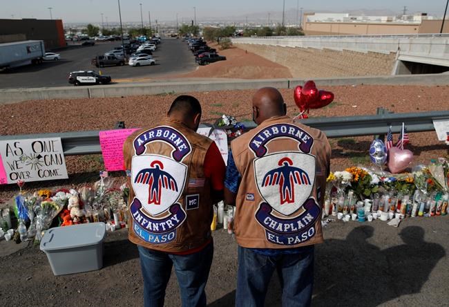 People pray a makeshift memorial for victims of a mass shooting at a shopping complex Monday, Aug. 5, 2019, in El Paso, Texas. (AP Photo/John Locher)