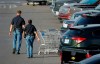 Police officers walk by shopping carts at the scene of a mass shooting at a shopping complex Sunday, Aug. 4, 2019, in El Paso, Texas. (AP Photo/John Locher)