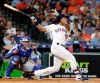 Houston Astros designated hitter Michael Brantley (23) watches his two-run home run hit in front of Kansas City Royals catcher Martin Maldonado, left, during the third inning of a baseball game, Wednesday, May 8, 2019, in Houston. (AP Photo/Michael Wyke)