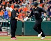 Los Angeles Angels shortstop Andrelton Simmons, right, low fives third base coach Mike Gallego, left, as he rounds the bases on his home run during the second inning of a baseball game against the Houston Astros Sunday, Aug. 25, 2019, in Houston. (AP Photo/Michael Wyke)