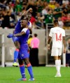 Haiti defender Carlens Arcus is held up by defender Andrew Jean Baptiste as Canada defender Mark-Anthony Kaye (14) walks off the field after Haiti defeated Canada 3-2 in a CONCACAF Gold Cup soccer quarterfinal Saturday, June 29, 2019, in Houston. (AP Photo/Michael Wyke)