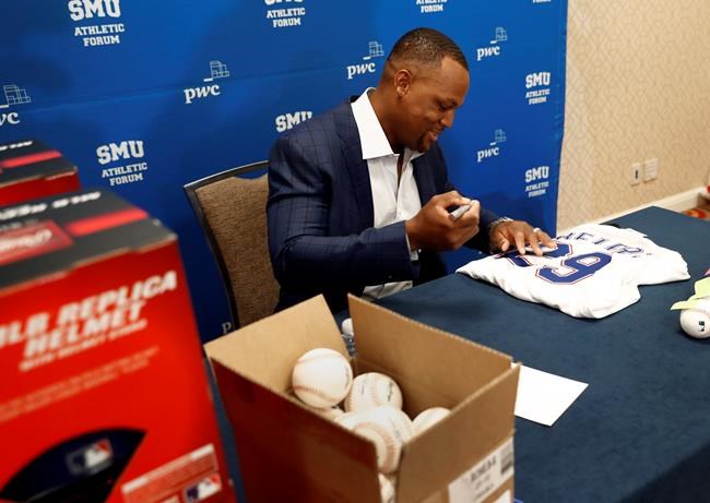 Adrian Beltre, retired MLB baseball player, autographs sports memorabilia before the start of a news conference during the SMU Athletic Forum in Dallas, Wednesday, May 15, 2019. (AP Photo/Tony Gutierrez)