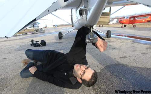 Joe Bryksa / Winnipeg Free Press
Tyler Walsh adjusts the heavily-duct taped GoPro camera mounted on the belly of a plane at Harv's Air in Steinbach.