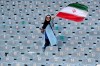 An Iranian woman waves her country's flag as she arrives at the Azadi Stadium to watch the 2022 World Cup qualifier soccer match between Iran and Cambodia, in Tehran, Iran, Thursday, Oct. 10, 2019. Iranian women are freely allowed into the stadium for the first time in decades. They had been banned since 1981. (AP Photo/Vahid Salemi)