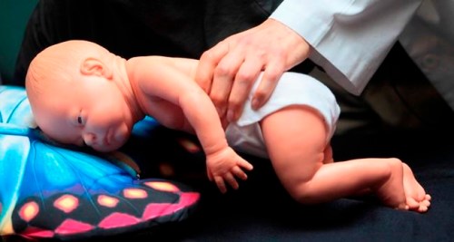 FILE - In this March 22, 2012 file photo, a doctor demonstrates how an infant can die due to unsafe sleeping practices using a scene re-enactment doll in Norfolk, Va. Released on Monday, April 22, 2019, an analysis of five years of CDC data found most accidental suffocation deaths in U.S. infants occur when babies are sleeping on their stomachs in adult beds with blankets and pillows. (AP Photo/The Virginian-Pilot, Steve Earley, File)