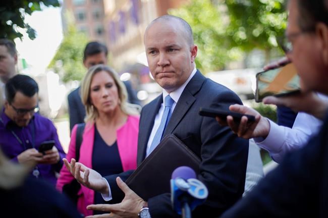 Joshua Stueve, public affairs officer with the U.S. Department of Justice U.S. Attorney's Office, speaks outside the the federal courthouse in Alexandria, Va., Thursday, Oct. 10, 2019. The two Florida businessmen, tied to President Donald Trump's personal lawyer Rudy Giuliani, have been arrested on campaign finance violations resulting from a $325,000 donation to a political action committee supporting President Donald Trump's re-election. (AP Photo/Pablo Martinez Monsivais)