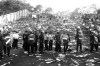 File - In this May 29, 1985 file photo, Belgian riot police stand in a line in front of debris littered stands, after a disastrous clash between rival soccer fans during the European Cup Final at the Heysel Stadium in Brussels. Local authorities, families of victims and survivors marked the 30th anniversary of the Heysel stadium tragedy Friday, May 29, 2015 to commemorate the 39 football fans who died during hooligan riots at the 1985 European Cup final between Liverpool and Juventus. (AP Photo, File)