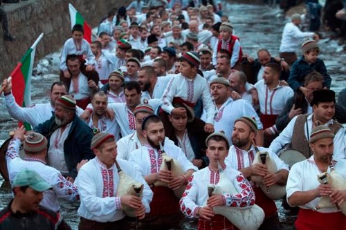 Bulgarians play bagpipes and sing in the icy waters of the Tundzha river in Kalofer, Bulgaria, Sunday, Jan. 6, 2019. Traditionally, an Eastern Orthodox priest throws a wooden cross in the river and it is believed that the one who retrieves it will be healthy through the year. In the mountain city of Kalofer, in central Bulgaria, dozens of men dressed in white embroidered shirts waded into the frigid Tundzha River waving national flags and singing folk songs. (AP Photo)