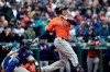 Houston Astros' Michael Brantley, right, and Seattle Mariners catcher Omar Narvaez watch the path of Brantley's two-run single in the sixth inning of a baseball game Sunday, April 14, 2019, in Seattle. (AP Photo/Elaine Thompson)