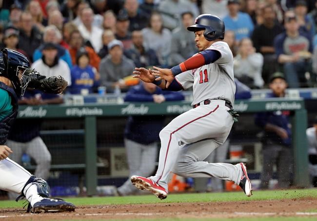 Minnesota Twins' Jorge Polanco (11) begins his slide home to score as Seattle Mariners catcher Tom Murphy readies a tag during the fifth inning of a baseball game Friday, May 17, 2019, in Seattle. (AP Photo/Elaine Thompson)