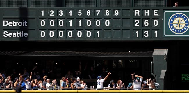 Fans reach for the home run ball of Seattle Mariners' Domingo Santana in the eighth inning of a baseball game against the Detroit Tigers Sunday, July 28, 2019, in Seattle. (AP Photo/Elaine Thompson)
