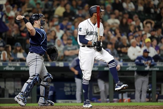 Seattle Mariners' Keon Broxton, right, reacts after striking out swinging in the eighth inning of a baseball game, as Tampa Bay Rays catcher Mike Zunino throws the ball Saturday, Aug. 10, 2019, in Seattle. (AP Photo/Elaine Thompson)