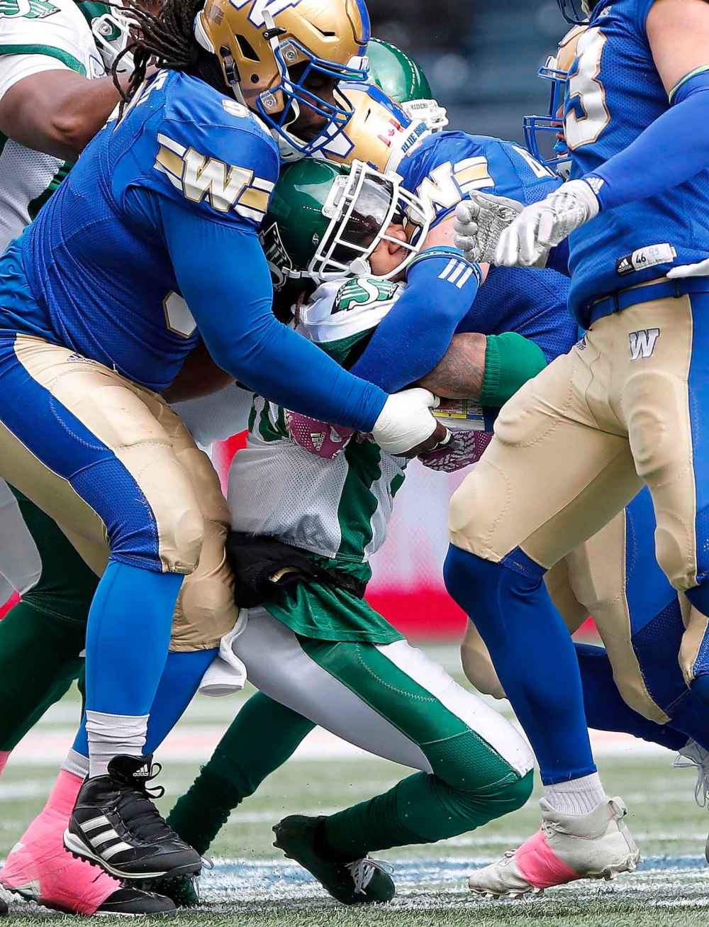 THE CANADIAN PRESS/John Woods
Winnipeg Blue Bombers defenders crush a Saskatchewan Roughriders' running back during the first half in Winnipeg last Saturday. The game had a definite playoff atmosphere according to Bombers GM Kyle Walters.