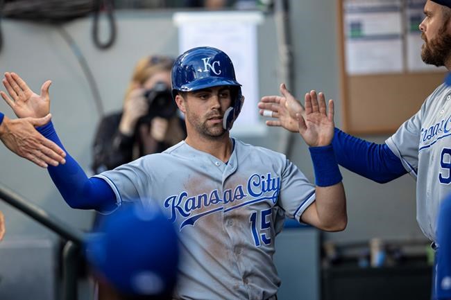 Kansas City Royals' Whit Merrifield is congratulated by teammates after scoring a run on a single by teammate Cheslor Cuthbert off Seattle Mariners starting pitcher Tayler Scott during the first inning of a baseball game, Monday, June 17, 2019, in Seattle. (AP Photo/Stephen Brashear)