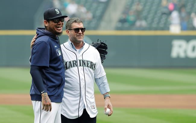 Seattle Mariners Hall-of-Famer and former designated hitter Edgar Martinez, right, poses for a photo with pitcher Felix Hernandez, left, after Hernandez caught Martinez throwing out the first pitch of a baseball game against the Tampa Bay Rays, Sunday, Aug. 11, 2019, in Seattle. (AP Photo/Ted S. Warren)